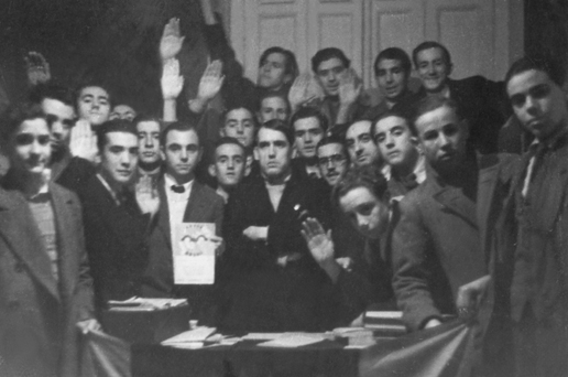 Ramiro Ledesma Ramos, en el centro de la imagen y con los brazos cruzados, en la sede de las JONS de Madrid rodeado de jóvenes militantes jonsistas. Ramiro Ledesma Ramos, en el centro de la imagen y con los brazos cruzados, en la sede de las JONS de Madrid rodeado de jóvenes militantes jonsistas.